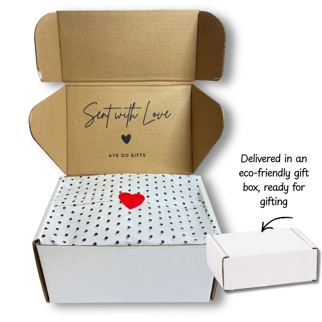 An open cardboard gift box from Aye Do Gifts, white tissue paper.