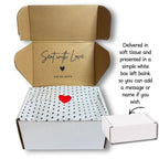 An open cardboard gift box from Aye Do Gifts with a white tissue paper lid printed with black polka dots and a small red heart. Text on the right explains the packaging, and a small closed white box is shown at the lower right.