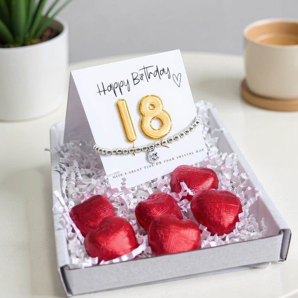 AyeDoGifts 18th birthday gift hamper with silver beaded bracelet, cubic zirconia charm, gold balloon '18' card, and red heart chocolates.