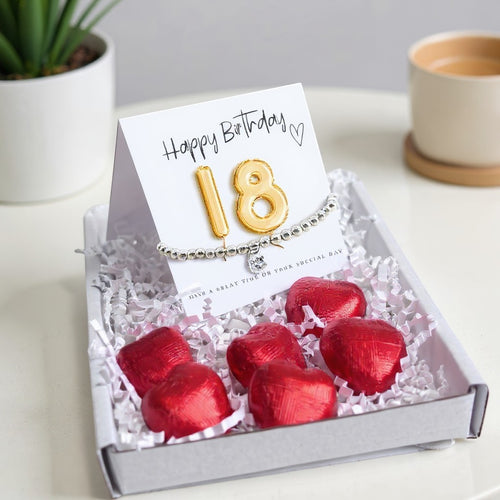 AyeDoGifts 18th birthday gift hamper with silver beaded bracelet, cubic zirconia charm, gold balloon '18' card, and red heart chocolates.