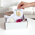 AyeDoGifts 18th birthday gift hamper with gold balloon necklace, vanilla candle, chocolates, and matches.