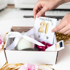 AyeDoGifts 21st birthday hamper with gold balloons, stud earrings, vanilla candle, chocolates, and matches.